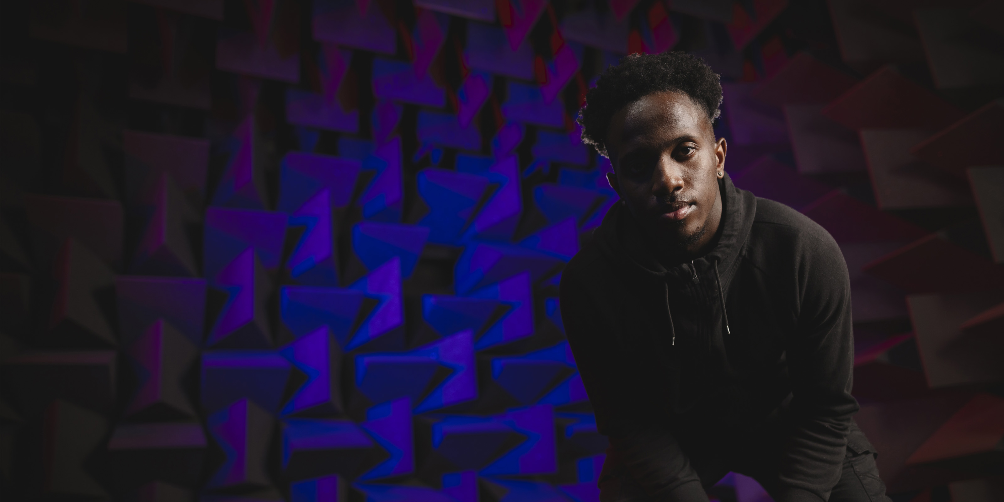 A student in a hoodie looking to camera