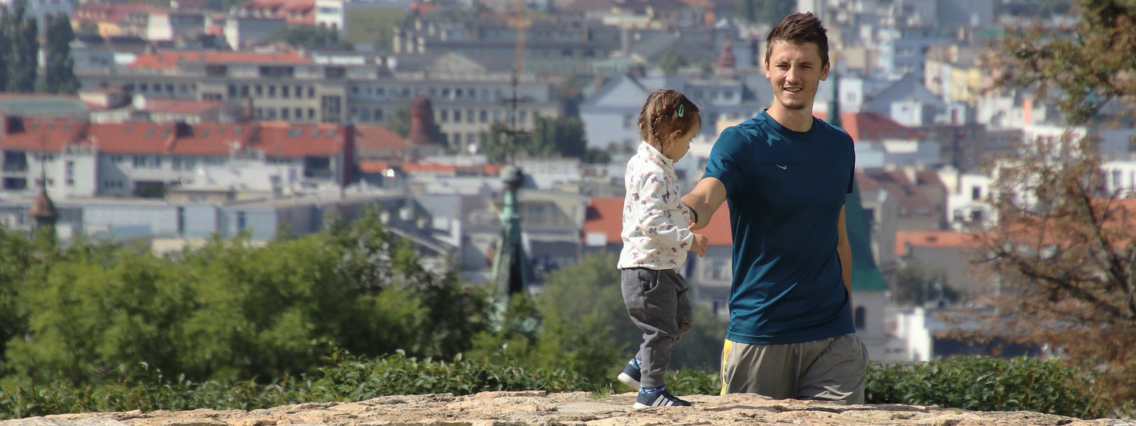A father walking with his child on a city wall